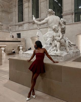 French woman wearing a burgundy dress.