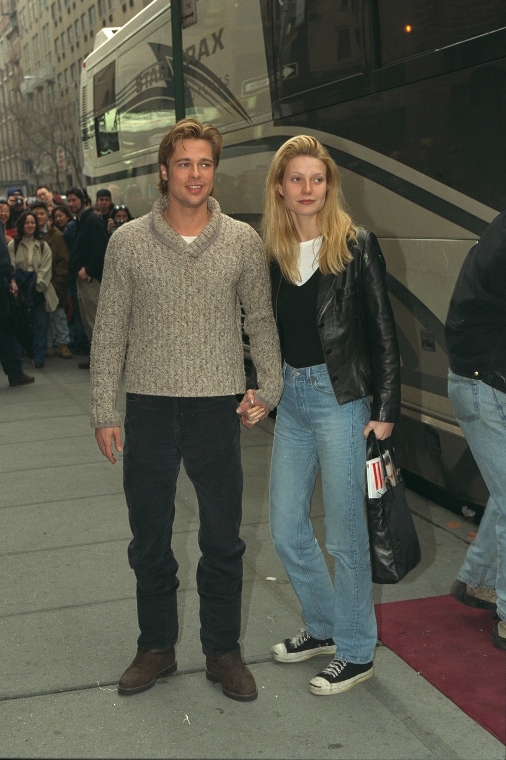 Image of Gwyneth Paltrow in the '90s wearing a v-neck jumper over a white t-shirt with blue jeans and black converse.